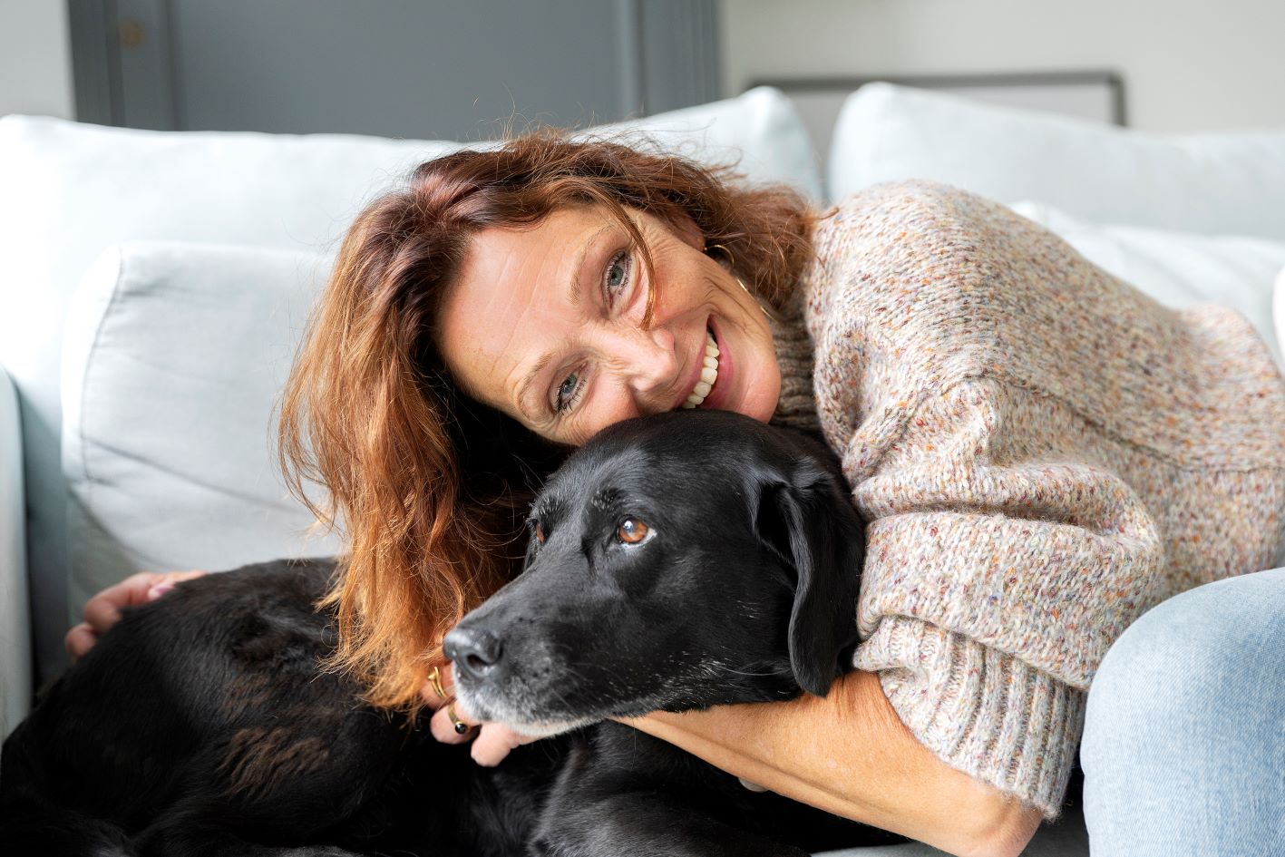 Thuispoort | blije vrouw met haar hond in nieuwe woning